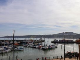 A harbor with boats docked and people walking near the water at Apartment 2 in Scarborough