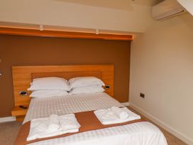 A bedroom with a double bed and white towels on a brown runner at Apartment 3 in Scarborough