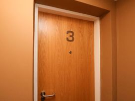 A wooden door with the number 3 and a door handle in a hallway at Apartment 3 Scarborough