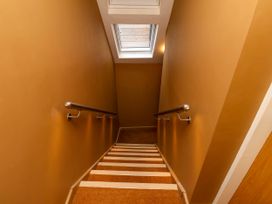 A staircase with metal handrails and a skylight window above at Apartment 3 in Scarborough