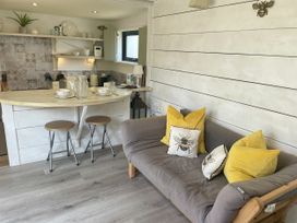 A kitchen with a counter and stools at The Cow Shed in Mawgan Porth
