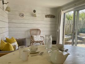 A dining room with a table set for tea at The Cow Shed in Mawgan Porth