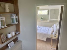 View into a bedroom with a bed and a plant at The Cow Shed in Mawgan Porth