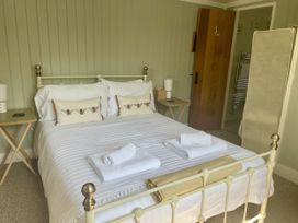 A bedroom with a bed and bedside tables at The Cow Shed in Mawgan Porth