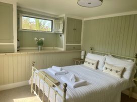 A bedroom with a bed and a lamp at The Cow Shed in Mawgan Porth