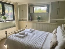 A bedroom with a bed and window at The Cow Shed in Mawgan Porth