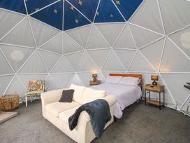 A dome-shaped room with a bed nightstands a sofa and a chair at Meadow View - Bryn-Mawr Retreat in Brynmawr near Llanymynech