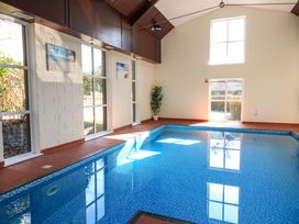 An indoor swimming pool with windows and wall art at Millers Loft in Modbury