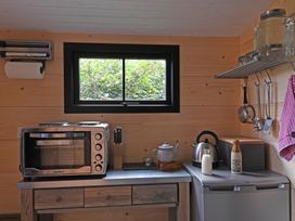 A compact kitchen area with an oven toaster microwave kettle and utensils at Bugail Hut in Llantwit Major