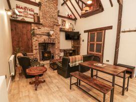 A living room with a fireplace and wooden furniture at Dotty's Den in Bridlington