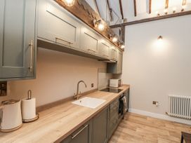 A kitchen with cabinets and sink at Dotty's Den in Bridlington