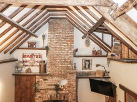 A snug with a brick fireplace and wooden beams at Dotty's Den in Bridlington