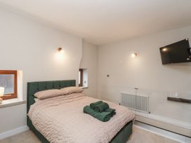 A bedroom with a bed and TV at Dotty's Den in Bridlington