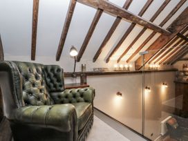 A loft area with an armchair and wall lights at Dotty's Den in Bridlington