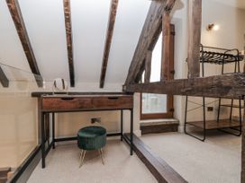 An attic room with a desk and clothing rack at Dotty's Den in Bridlington
