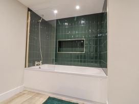 A bathroom with a bathtub and shower area at Dotty's Den in Bridlington