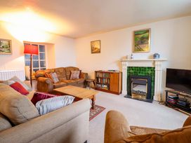 A living room with a fireplace and sofa at Garth Celyn in Porthmadog
