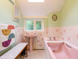 A bathroom with a pink bath and sink at Garth Celyn in Porthmadog