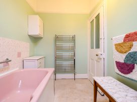 A bathroom with a bathtub and shelves at Garth Celyn in Porthmadog