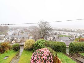 A view of a town with houses and boats by a water body at Garth Celyn in Porthmadog
