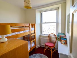 A bedroom with a bunk bed and a chair at Garth Celyn in Porthmadog