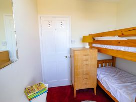 A bedroom with a bunk bed and dresser at Garth Celyn in Porthmadog