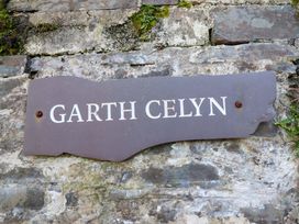 A sign displaying Garth Celyn on a stone wall in Porthmadog
