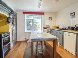 A kitchen with a table and appliances at Garth Celyn in Porthmadog