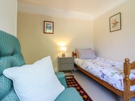 A bedroom with a bed and chair at Garth Celyn Porthmadog