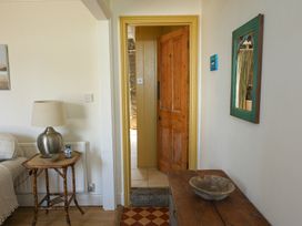 A hallway with a door and table at Kittiwake in Newlyn