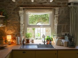 A kitchen with a sink and window at Kittiwake in Newlyn