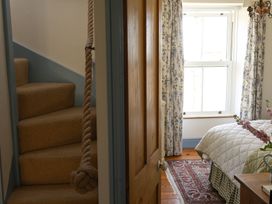 A bedroom with a staircase and window at Kittiwake in Newlyn