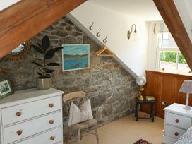 A bedroom with a chest of drawers and a chair at Kittiwake in Newlyn