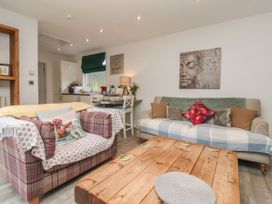 A living room with two sofas a wooden coffee table and a kitchen area in the background at Ellesmere Cottage in Hornsea