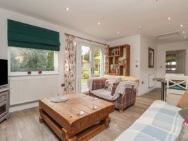 A living room with wooden coffee table sofas and French doors at Ellesmere Cottage in Hornsea