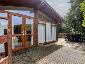 An outdoor deck with a table and chairs at Newton Calm in Newton Ferrers
