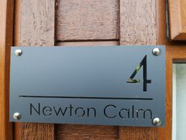 An address plaque with number 4 and Newton Calm at Newton Ferrers