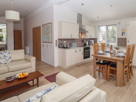 An open plan living area with kitchen and dining table at Newton Calm in Newton Ferrers