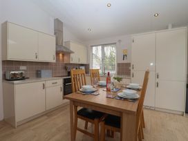 A kitchen with table and chairs at Newton Calm in Newton Ferrers