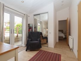 A hallway with double doors and a chair at Newton Calm in Newton Ferrers