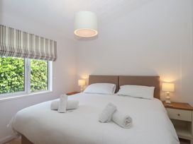 A bedroom with a bed and bedside lamps at Newton Calm in Newton Ferrers