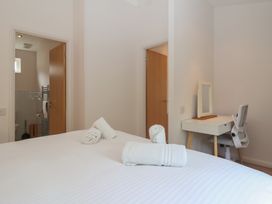 A bedroom with a bed, desk, and towels at Newton Calm in Newton Ferrers