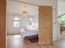 A bedroom with a bed and windows at Newton Calm in Newton Ferrers