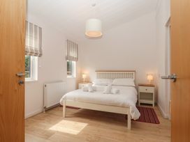 A bedroom with a bed and nightstands at Newton Calm in Newton Ferrers