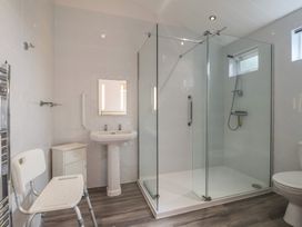 A bathroom with a shower, sink, and toilet at Newton Calm in Newton Ferrers