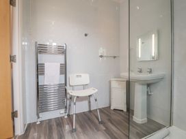 A bathroom with a shower, sink, towel rail, and cabinet at Newton Calm in Newton Ferrers