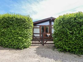 An outdoor view of a property with a gate and shrubs at Newton Calm in Newton Ferrers