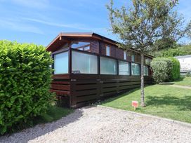A wooden house with glass panels in an outdoor area at Skyview in Newton Ferrers