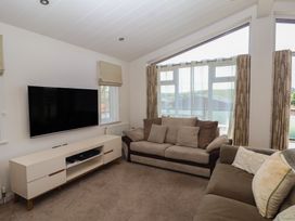 A living room with a sofa and television at Skyview in Newton Ferrers