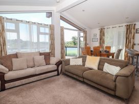 A living room with a sofa and dining area at Skyview in Newton Ferrers